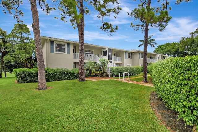 exterior space featuring a yard and a balcony