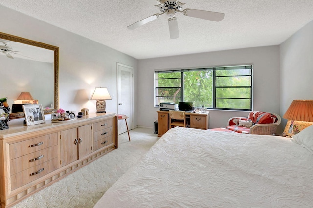 bedroom with a textured ceiling, light colored carpet, and ceiling fan