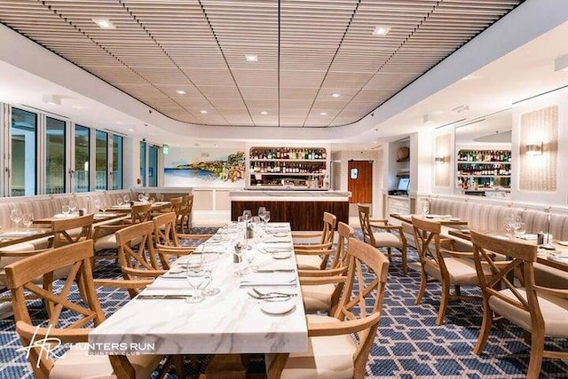 dining space featuring a raised ceiling, bar, and billiards