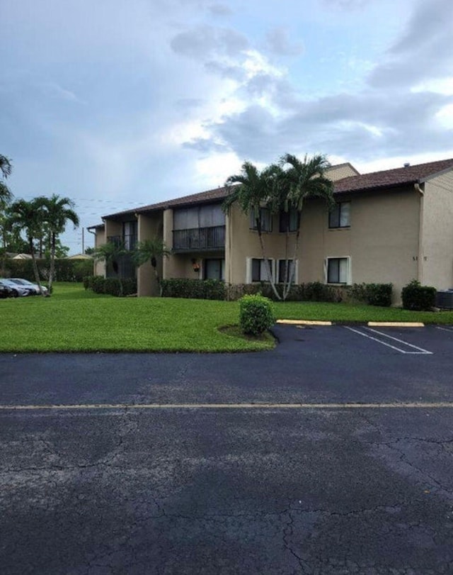 view of front of house with a balcony and a front yard