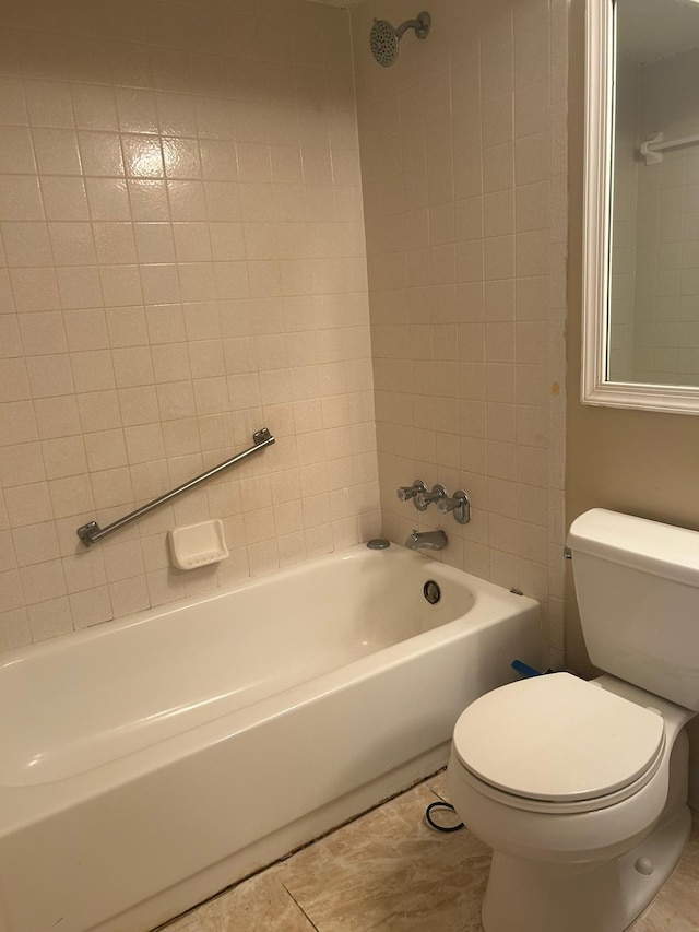 bathroom with tiled shower / bath, tile patterned flooring, and toilet