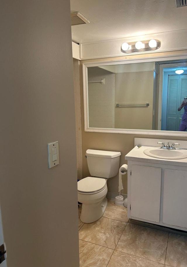 bathroom featuring vanity, toilet, and tile patterned flooring