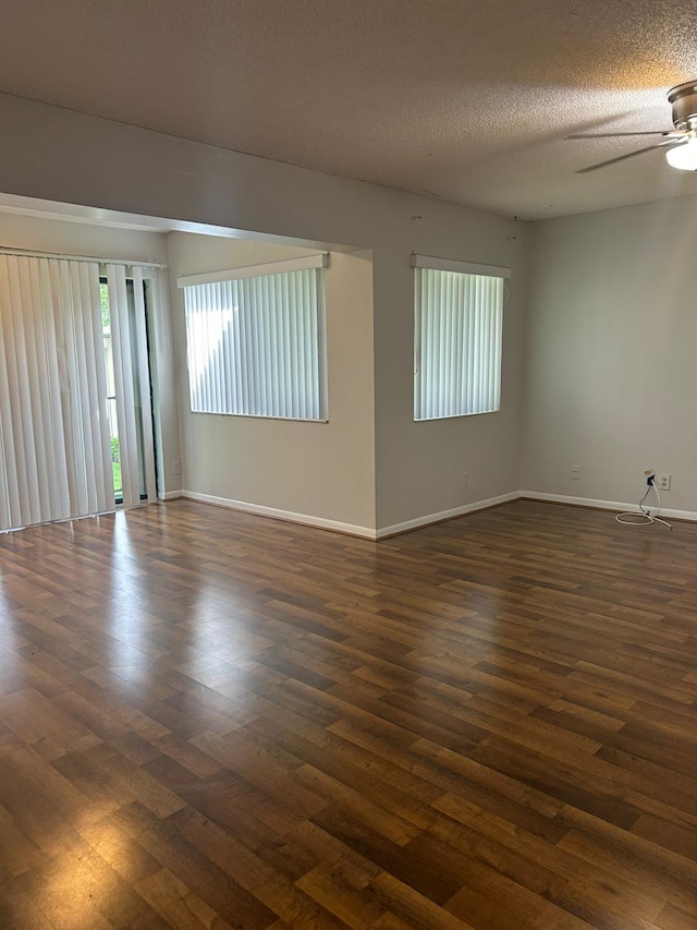 empty room with a textured ceiling, dark hardwood / wood-style flooring, and ceiling fan