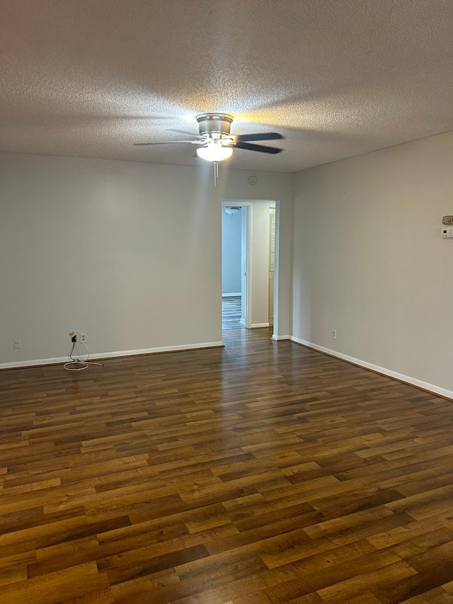 unfurnished room with ceiling fan, dark wood-type flooring, and a textured ceiling