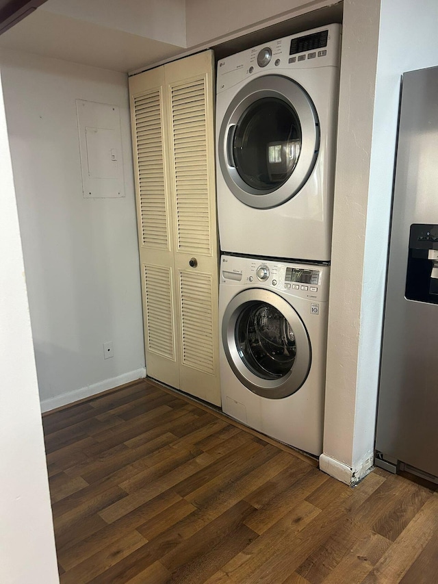 washroom featuring stacked washer / drying machine, electric panel, and dark hardwood / wood-style floors