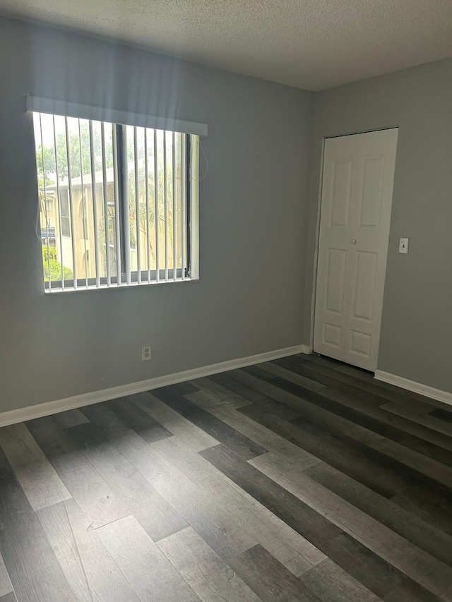 spare room featuring wood-type flooring and a textured ceiling