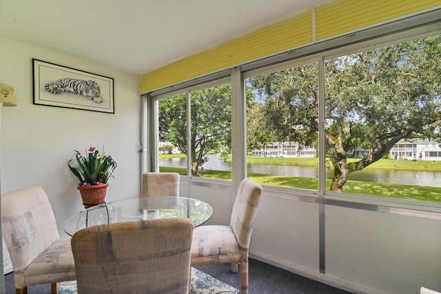 sunroom featuring a water view