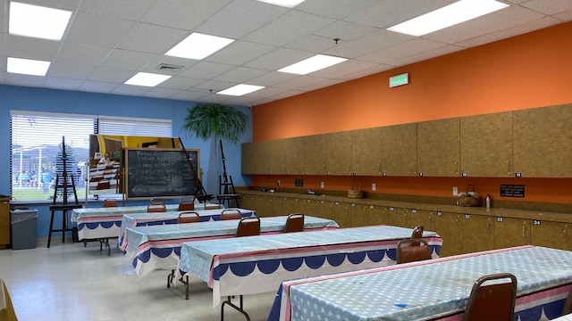 dining area with a drop ceiling and concrete floors