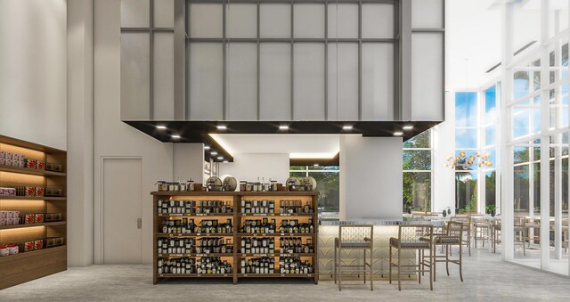 interior space with decorative backsplash, a high ceiling, and wall chimney range hood