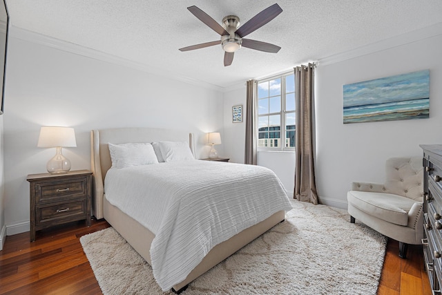 bedroom with dark wood-type flooring, a textured ceiling, ornamental molding, and ceiling fan