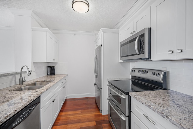 kitchen featuring stainless steel appliances, decorative backsplash, dark hardwood / wood-style floors, light stone countertops, and white cabinetry