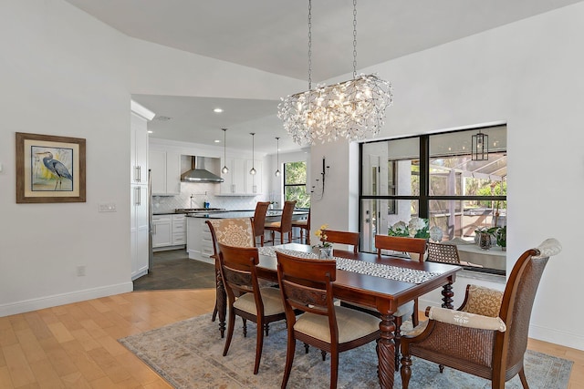 dining area with baseboards, vaulted ceiling, light wood-type flooring, a notable chandelier, and recessed lighting