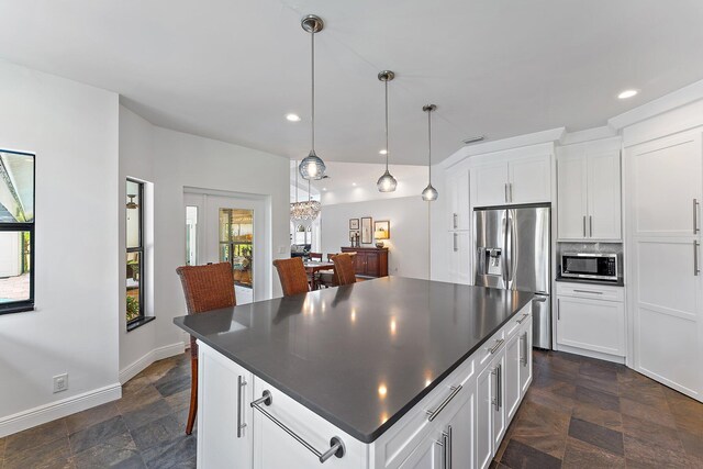 kitchen with wall chimney exhaust hood, stainless steel appliances, wine cooler, decorative light fixtures, and white cabinets