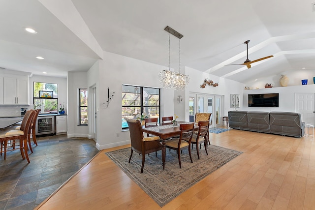 dining area with high vaulted ceiling, recessed lighting, beverage cooler, baseboards, and light wood-style floors