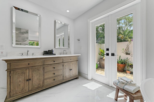 bathroom with double vanity, marble finish floor, a sink, and recessed lighting