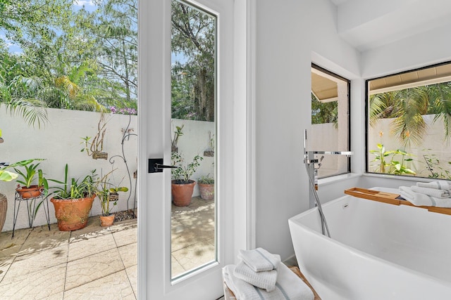 full bath featuring a freestanding tub and plenty of natural light