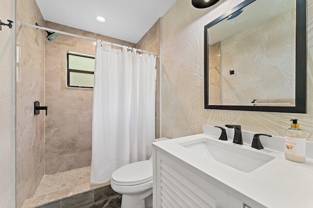bathroom with a shower stall, vanity, and toilet