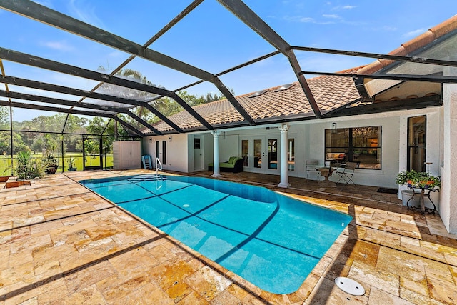 pool featuring glass enclosure, french doors, a patio area, and a ceiling fan