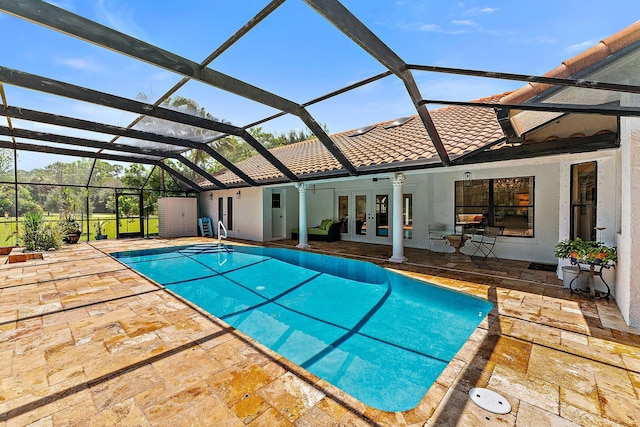 view of swimming pool with glass enclosure, ceiling fan, french doors, and a patio