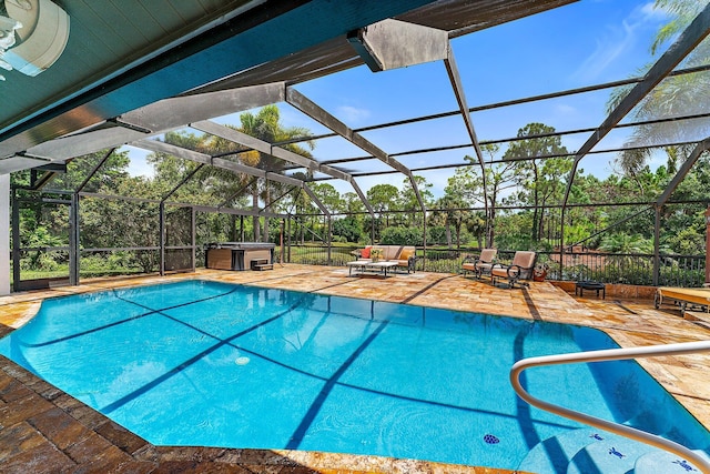 view of swimming pool featuring outdoor lounge area, a hot tub, glass enclosure, and a patio area