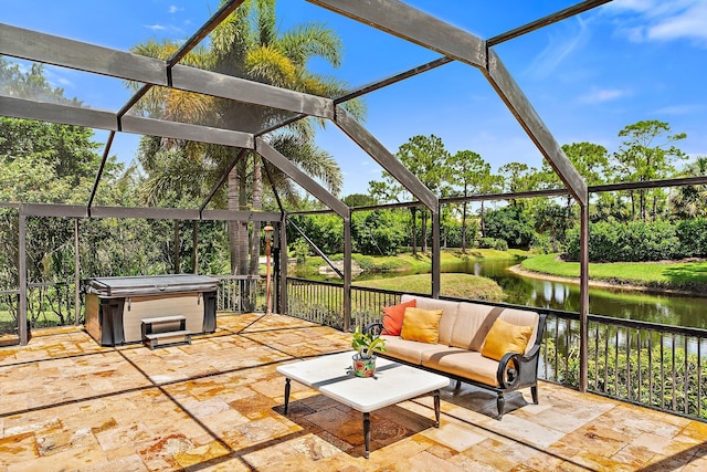 view of patio / terrace featuring a water view, a hot tub, a lanai, and an outdoor hangout area
