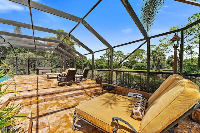 view of patio / terrace with a lanai and a hot tub