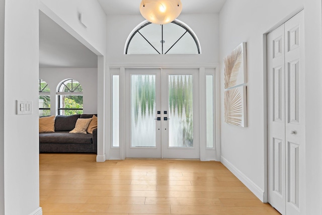 entrance foyer with french doors, light wood-type flooring, and baseboards
