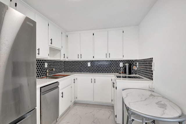 kitchen featuring white cabinetry, tasteful backsplash, appliances with stainless steel finishes, and sink