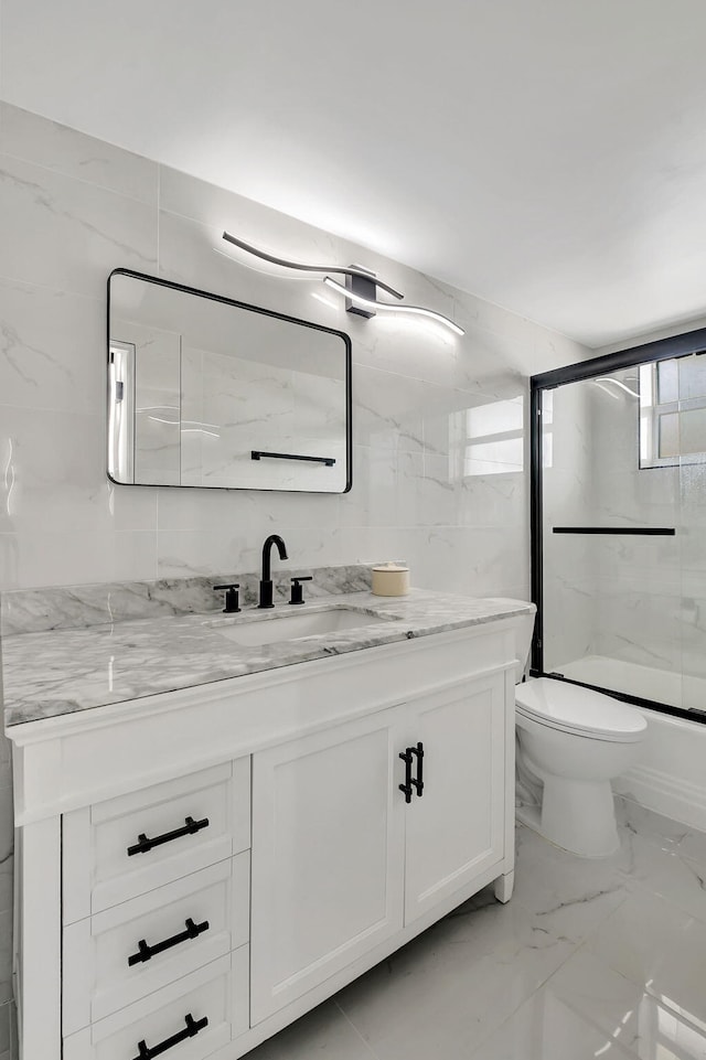 full bathroom with vanity, toilet, and shower / bath combination with glass door