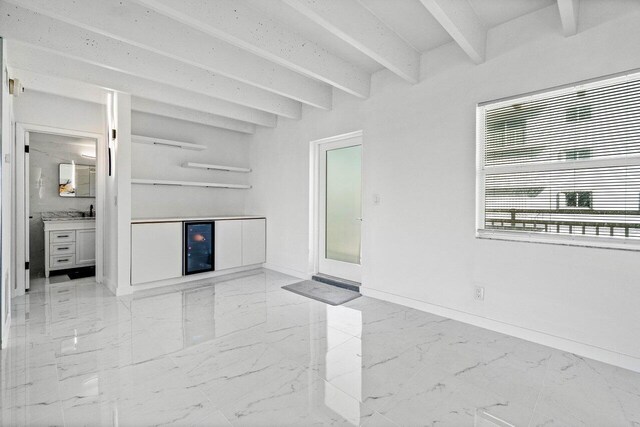 unfurnished living room featuring beamed ceiling