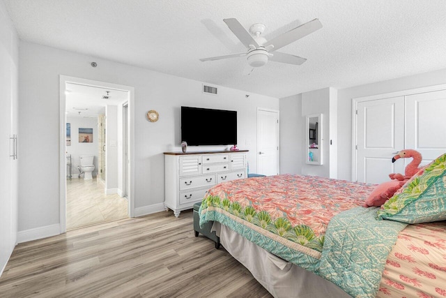 bedroom with light hardwood / wood-style floors, ceiling fan, and a textured ceiling