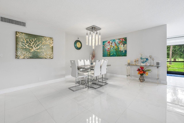 dining room featuring tile patterned flooring and a textured ceiling