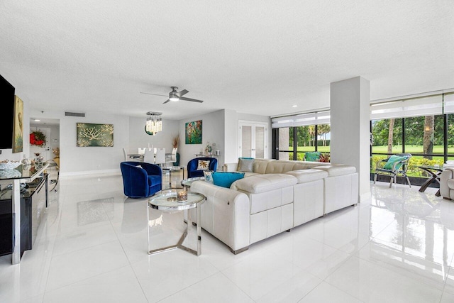 living room featuring a textured ceiling, ceiling fan, and light tile patterned floors