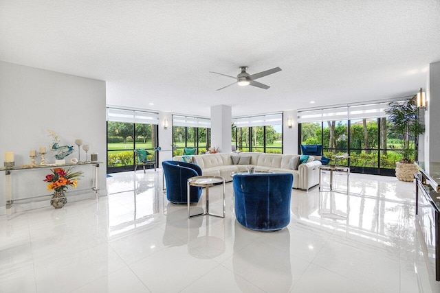 living room featuring ceiling fan, a textured ceiling, floor to ceiling windows, and light tile patterned floors