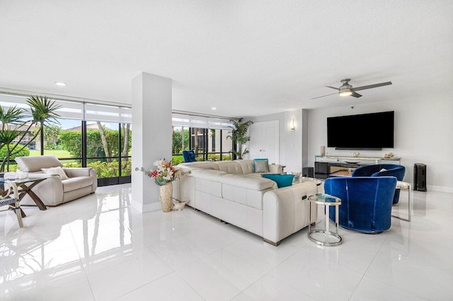 living room featuring ceiling fan, a textured ceiling, expansive windows, and light tile patterned flooring