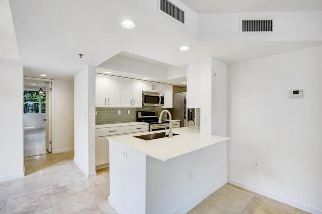 kitchen featuring light tile patterned floors, appliances with stainless steel finishes, backsplash, ceiling fan, and sink