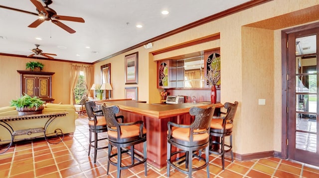 interior space featuring recessed lighting, tile patterned flooring, a breakfast bar area, and ornamental molding