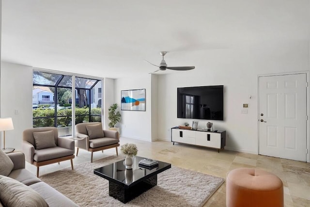 living area with expansive windows, a ceiling fan, and baseboards