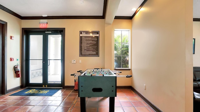 recreation room featuring tile patterned floors, french doors, and crown molding