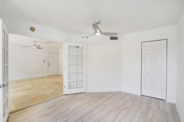 spare room with ceiling fan, french doors, and light hardwood / wood-style floors