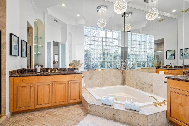 bathroom featuring vanity, wood-type flooring, ornamental molding, and separate shower and tub