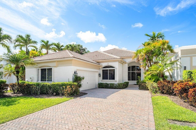 mediterranean / spanish-style house with a garage and a front yard