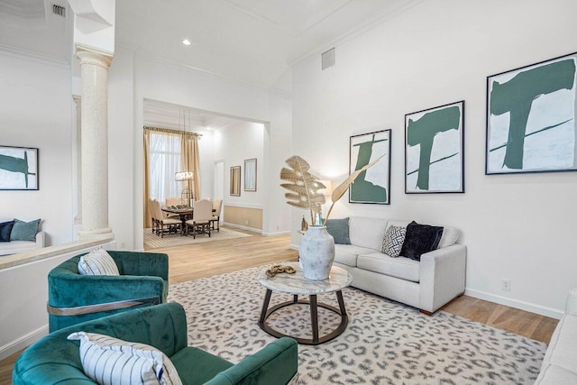 living room featuring ornamental molding, hardwood / wood-style flooring, and decorative columns