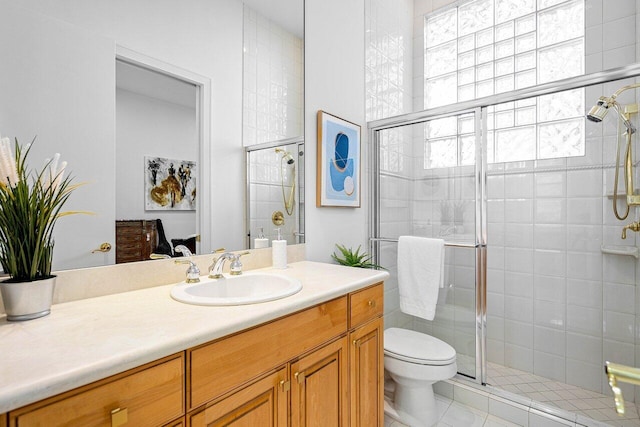 bathroom with toilet, vanity, tile patterned floors, and a shower with door