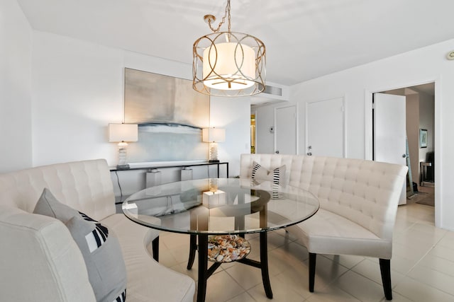 living area featuring light tile patterned flooring, visible vents, and an inviting chandelier