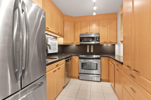 kitchen with stainless steel appliances, light tile patterned floors, sink, rail lighting, and light brown cabinets