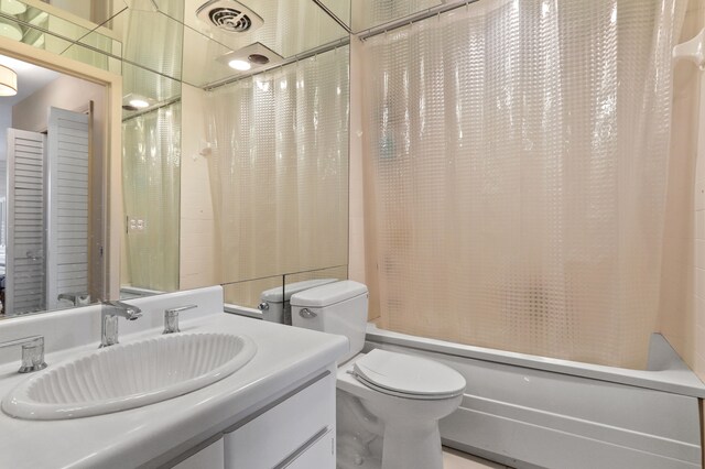 full bathroom with vanity, shower / bathtub combination with curtain, and toilet