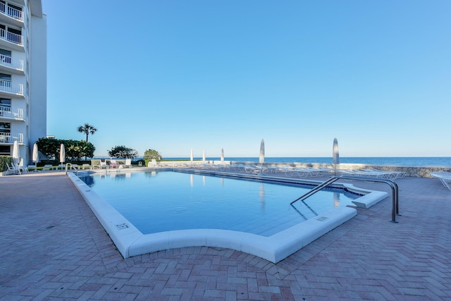 view of swimming pool with a water view