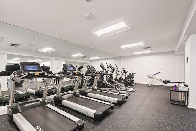 exercise room with visible vents and baseboards