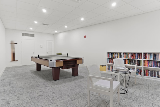 recreation room featuring a drop ceiling and light carpet